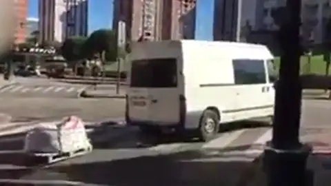 Una furgoneta conduce con un palé de madera enganchado a la parte trasera Una furgoneta conduce con un palé de madera enganchado a la parte trasera