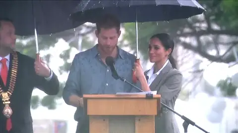 Polémica por la imagen de Meghan sujetándole el paraguas al príncipe Harry durante un discurso Polémica por la imagen de Meghan sujetándole el paraguas al príncipe Harry durante un discurso