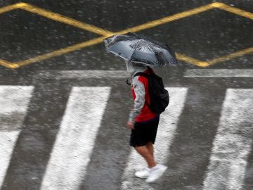 Una persona se protege de la lluvia con un paraguas.