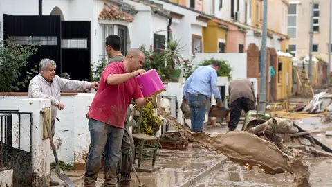 Un hombre limpiando los efectos de las lluvias Un hombre limpiando los efectos de las lluvias