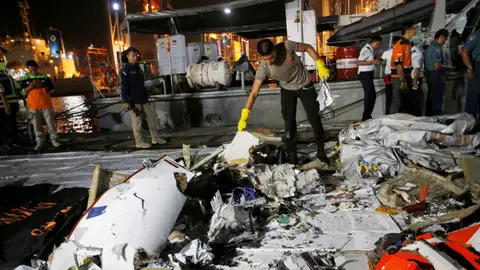 Un policía indonesio busca entre los restos Accidente Lion Air