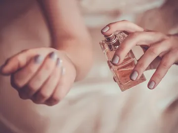 Mujer se echa colonia en el brazo Mujer se echa colonia en el brazo