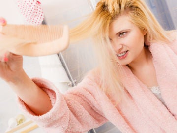 Mujer trata de peinarse el pelo