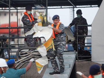 Equipo de emergencias cargando un trozo del avión siniestrado de Lion Air