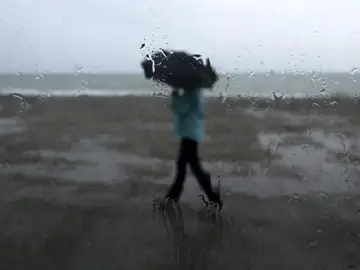 Un hombre se protege de la lluvia Un hombre se protege de la lluvia