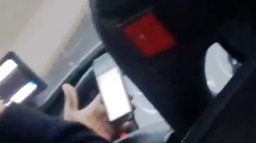 Un chófer de autobús utilizando el móvil mientras conduce