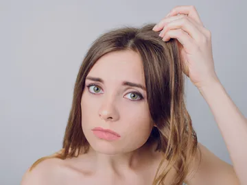 Mujer mira su pelo preocupada Mujer mira su pelo preocupada