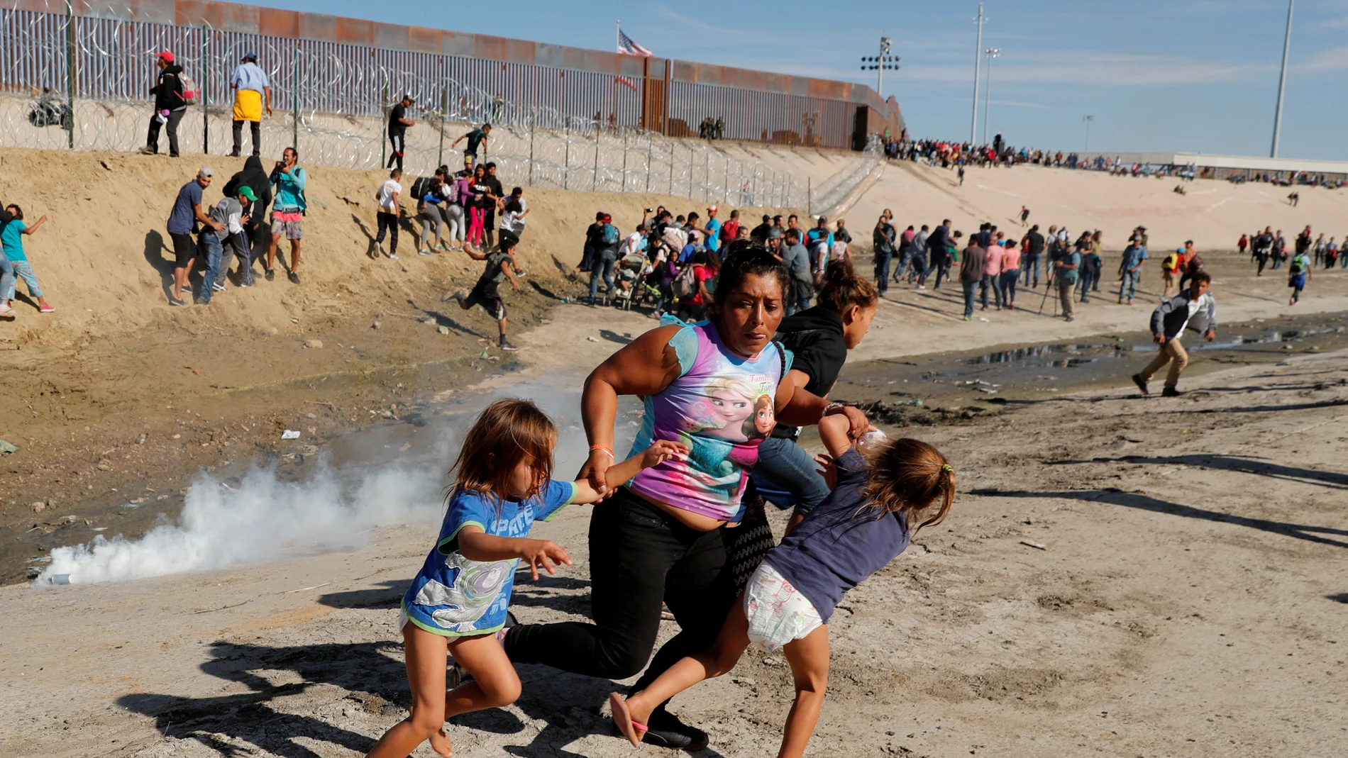 Mujer hondureña que forma parte de la caravana hacia EE.UU. huye con sus hijas de los gases lacrimógenos Mujer hondureña que forma parte de la caravana hacia EE.UU. huye con sus hijas de los gases lacrimógenos