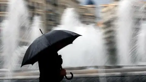 Imagen de archivo. Una persona se resguarda de la lluvia con un paraguas en el centro de Valencia