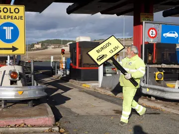 Un operario retira la señalización del peaje Un operario retira la señalización del peaje