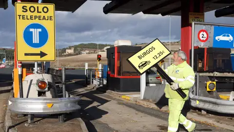 Un operario retira la señalización del peaje Un operario retira la señalización del peaje
