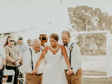 La joven caminando hacia el altar con su padre y su padrastro La joven caminando hacia el altar con su padre y su padrastro