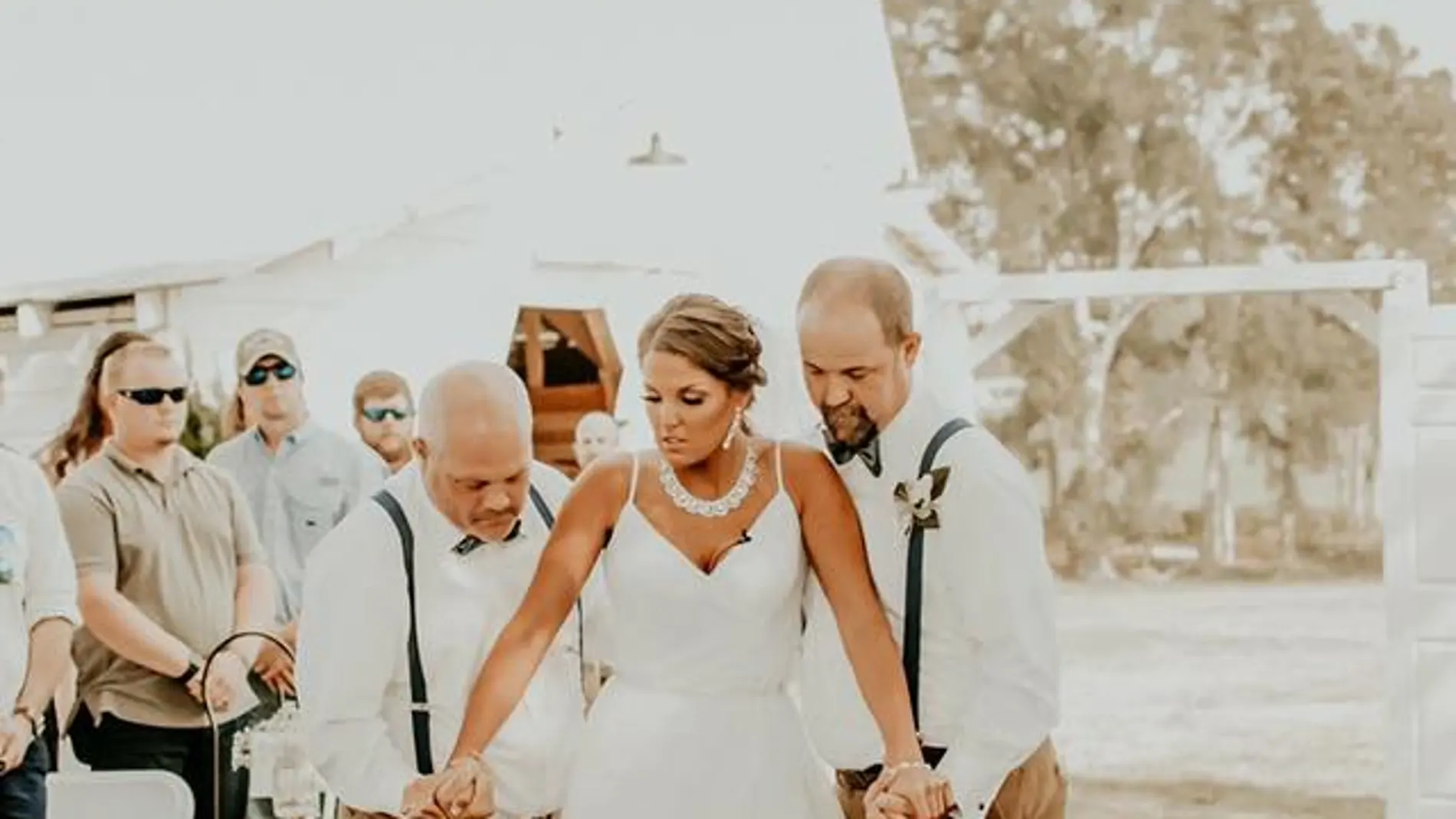 La joven caminando hacia el altar con su padre y su padrastro La joven caminando hacia el altar con su padre y su padrastro
