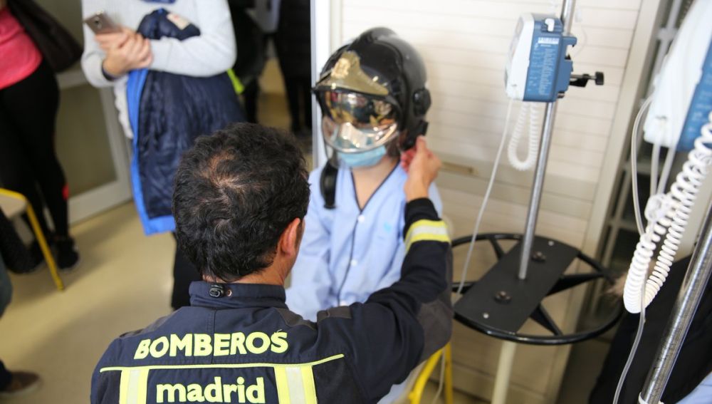 Un bombero con un niño ingresado en el Hospital La Paz