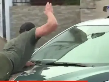 Un vecino sobre el coche de la Guardia Civil Un vecino sobre el coche de la Guardia Civil