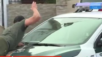 Un vecino sobre el coche de la Guardia Civil Un vecino sobre el coche de la Guardia Civil