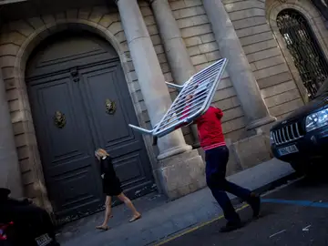 Un operario transporta vallas en el perímetro de la Llotja de Mar de Barcelona Un operario transporta vallas en el perímetro de la Llotja de Mar de Barcelona