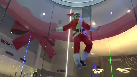 Un Papá Noel volador recoge las cartas de los niños desde un túnel de viento Un Papá Noel volador recoge las cartas de los niños desde un túnel de viento