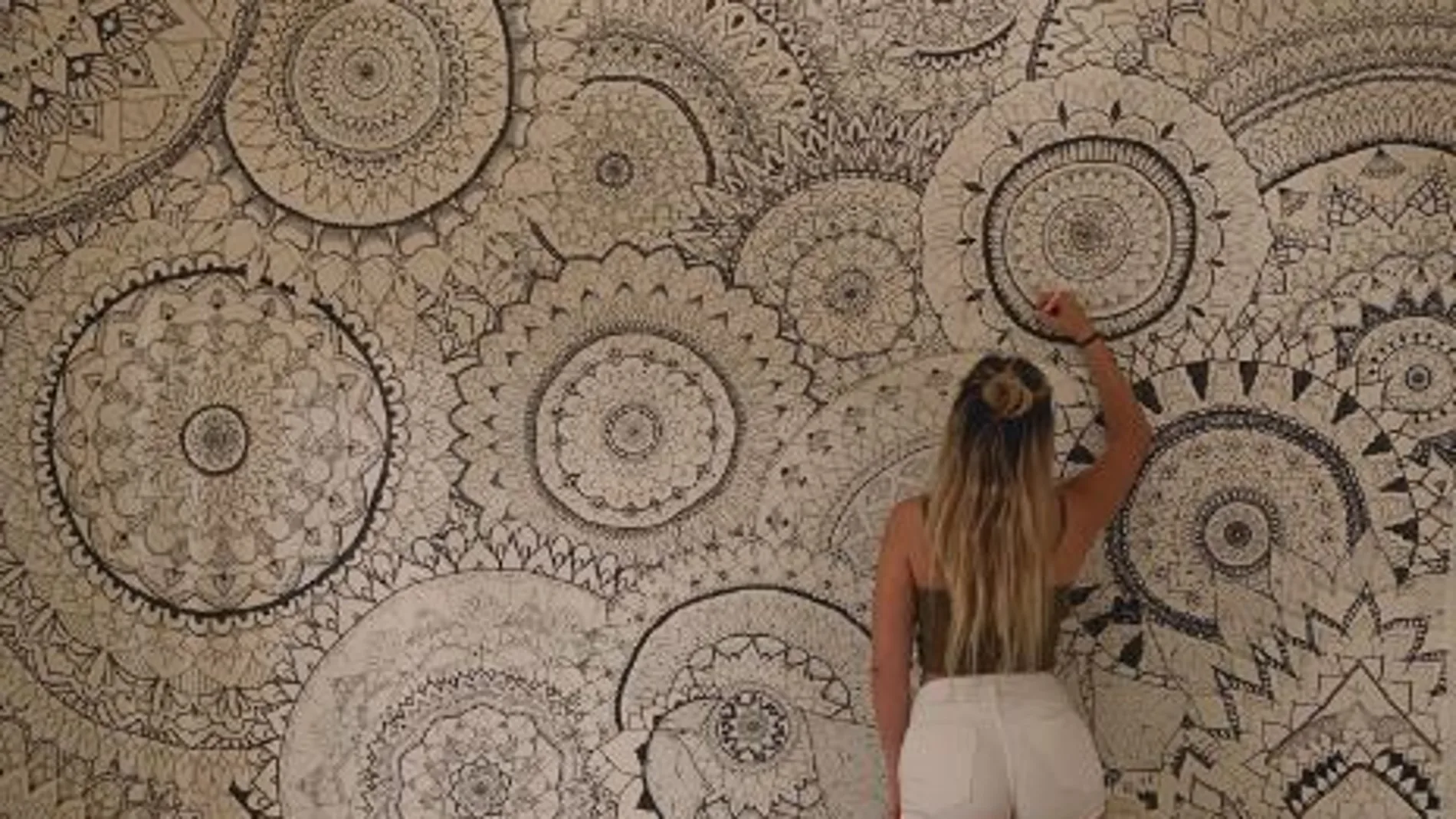 Una chica pinta mandalas en las paredes de su habitación Una chica pinta mandalas en las paredes de su habitación