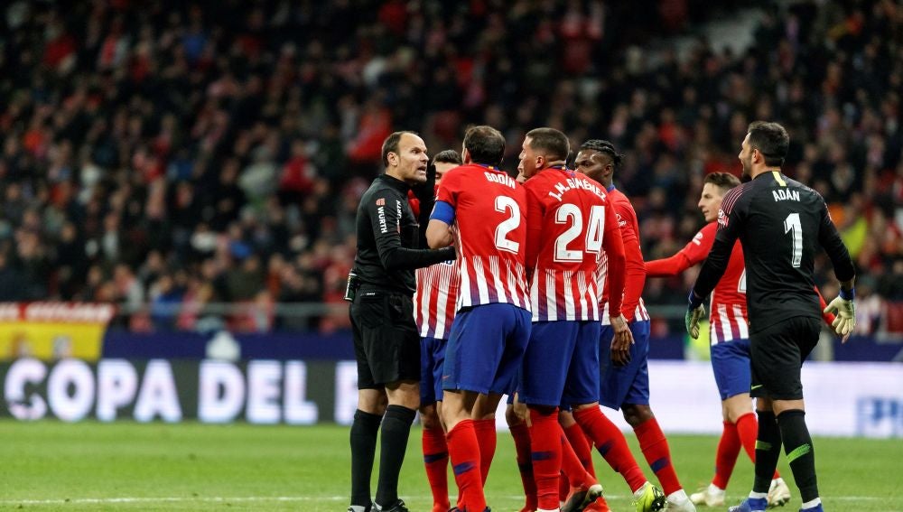 Los jugadores del Atlético discutiendo con Mateu Lahoz