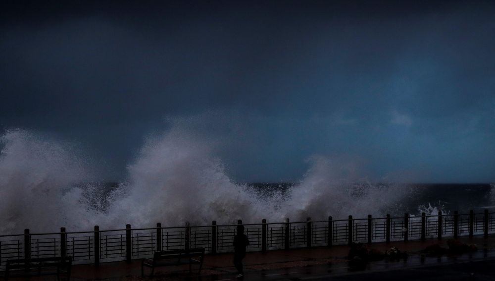 Una mujer es sorprendida por una ola en el Paseo Nuevo de San Sebastián