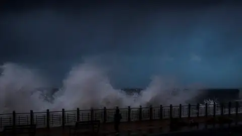 Una mujer es sorprendida por una ola en el Paseo Nuevo de San Sebastián Una mujer es sorprendida por una ola en el Paseo Nuevo de San Sebastián
