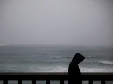 Un hombre camina bajo la lluvia por el paseo marítimo de A Coruña Un hombre camina bajo la lluvia por el paseo marítimo de A Coruña