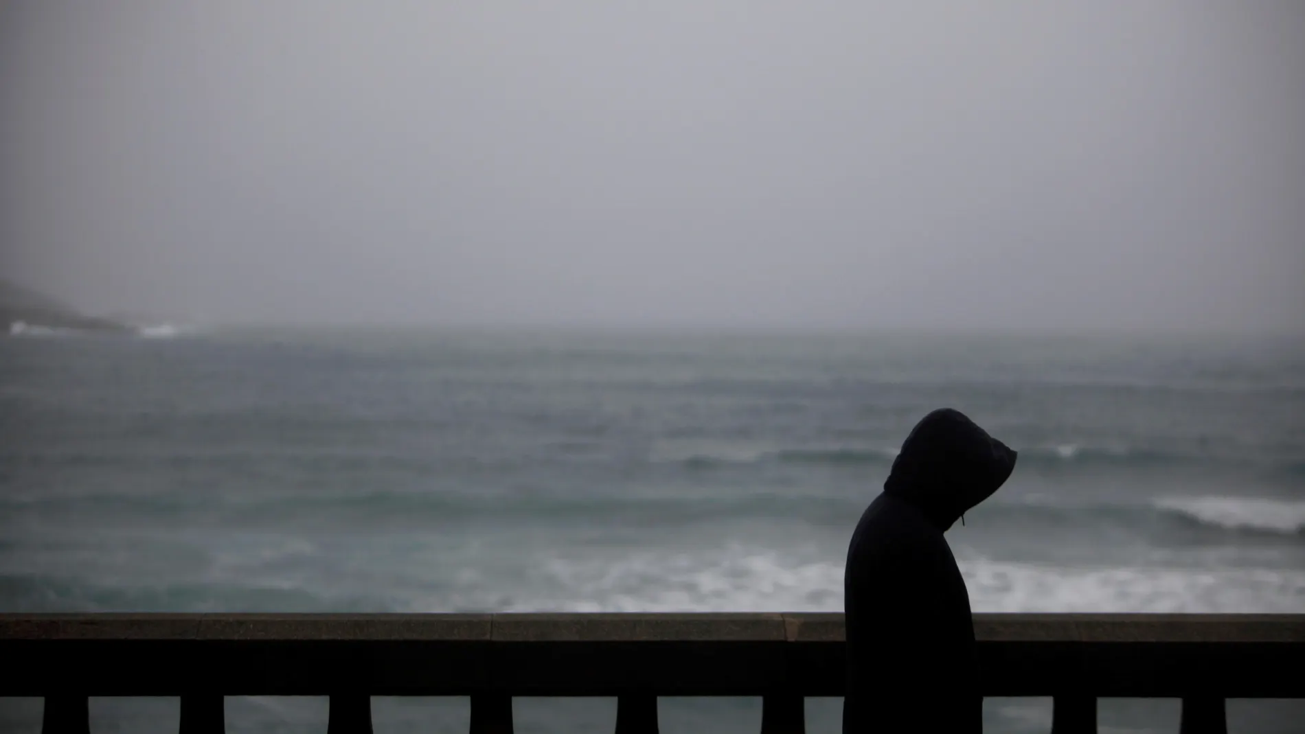 Un hombre camina bajo la lluvia por el paseo marítimo de A Coruña Un hombre camina bajo la lluvia por el paseo marítimo de A Coruña