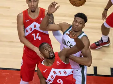 Giannis Antetokounmpo y Serge Ibaka pelean por un balón Giannis Antetokounmpo y Serge Ibaka pelean por un balón