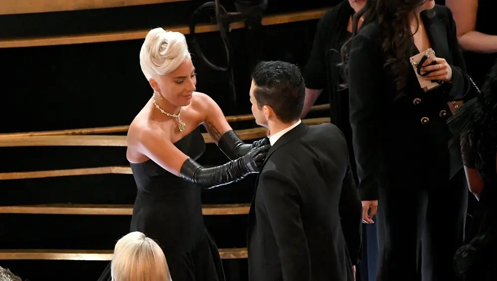 Lady Gaga arreglando la pajarita a Rami Malek