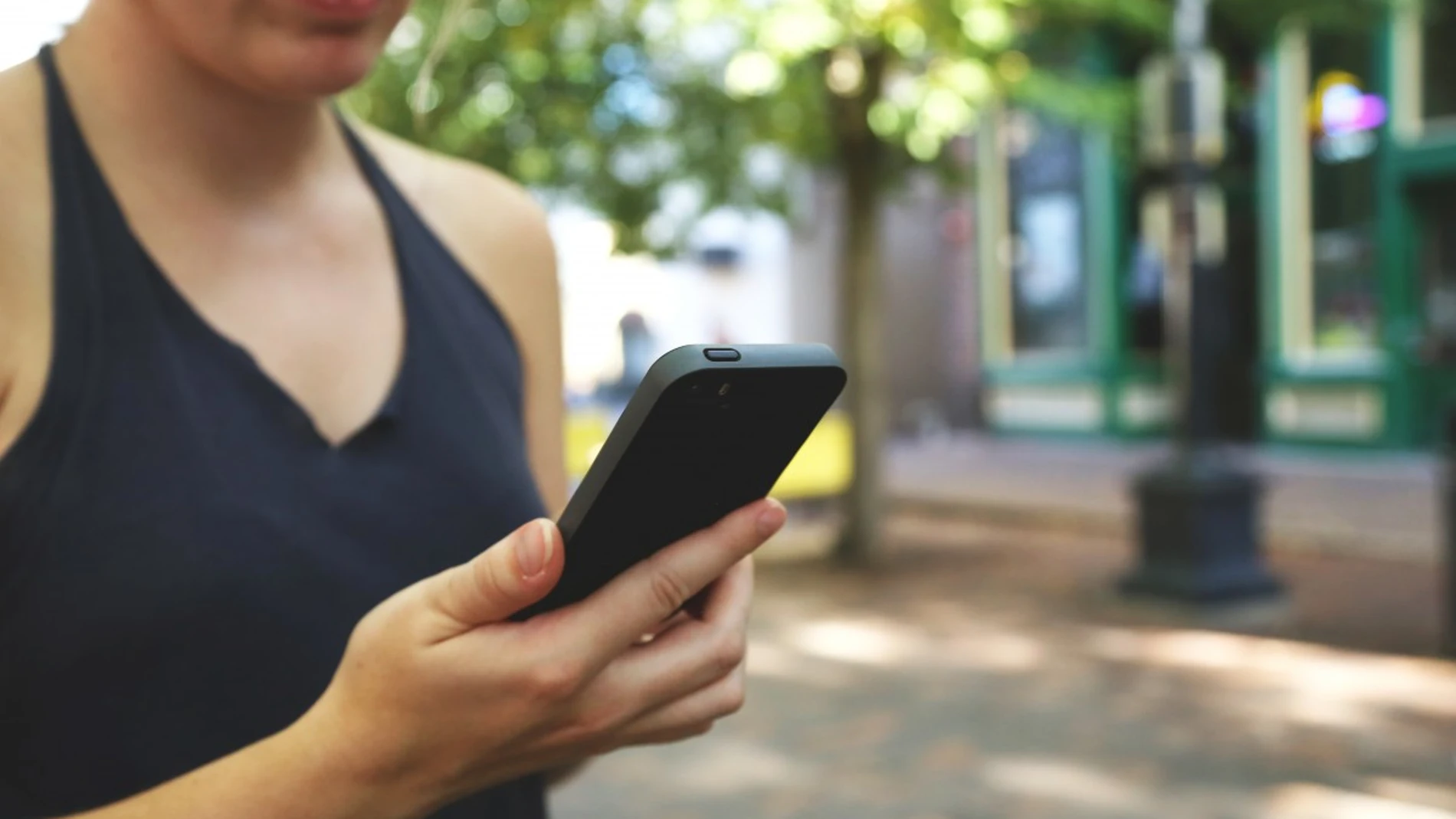 Una usuaria con su teléfono móvil Una usuaria con su teléfono móvil