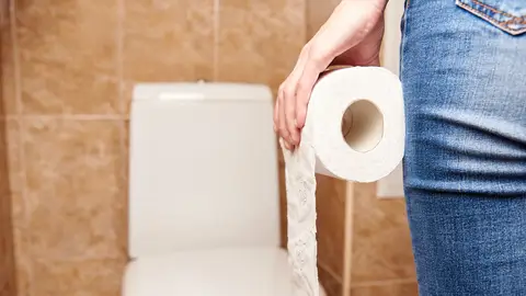 Chica en el aseo con papel higiénico Chica en el aseo con papel higiénico