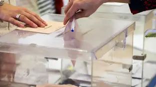Imagen de archivo de una persona depositando un voto en una urna Una mujer deposita su voto en una urna electoral