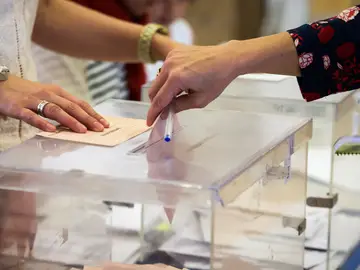 Imagen de archivo de una persona depositando un voto en una urna Imagen de archivo de una persona depositando un voto en una urna