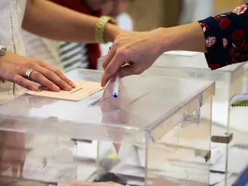 Imagen de archivo de una persona depositando un voto en una urna Imagen de archivo de una persona depositando un voto en una urna