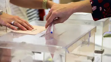 Una mujer deposita su voto en una urna electoral