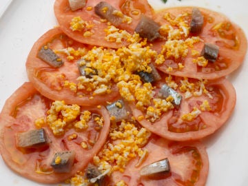 Ensalada de tomate, sardina ahumada y huevo rallado 