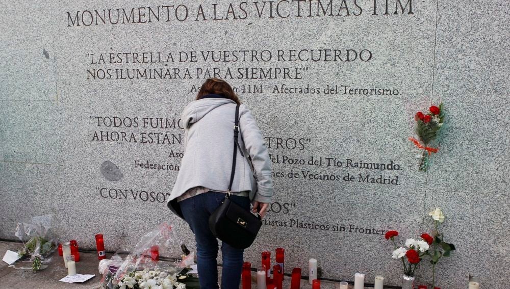 Flores y velas junto al monumento a las víctimas de los atentados del 11M