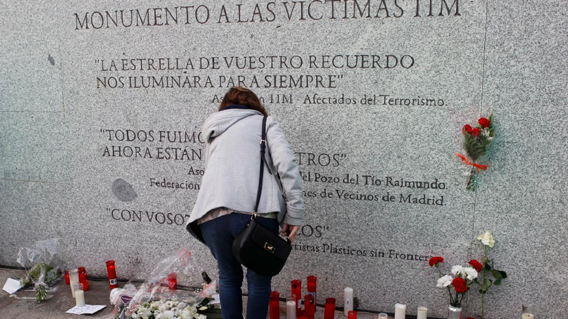 Flores y velas junto al monumento a las víctimas de los atentados del 11M Flores y velas junto al monumento a las víctimas de los atentados del 11M