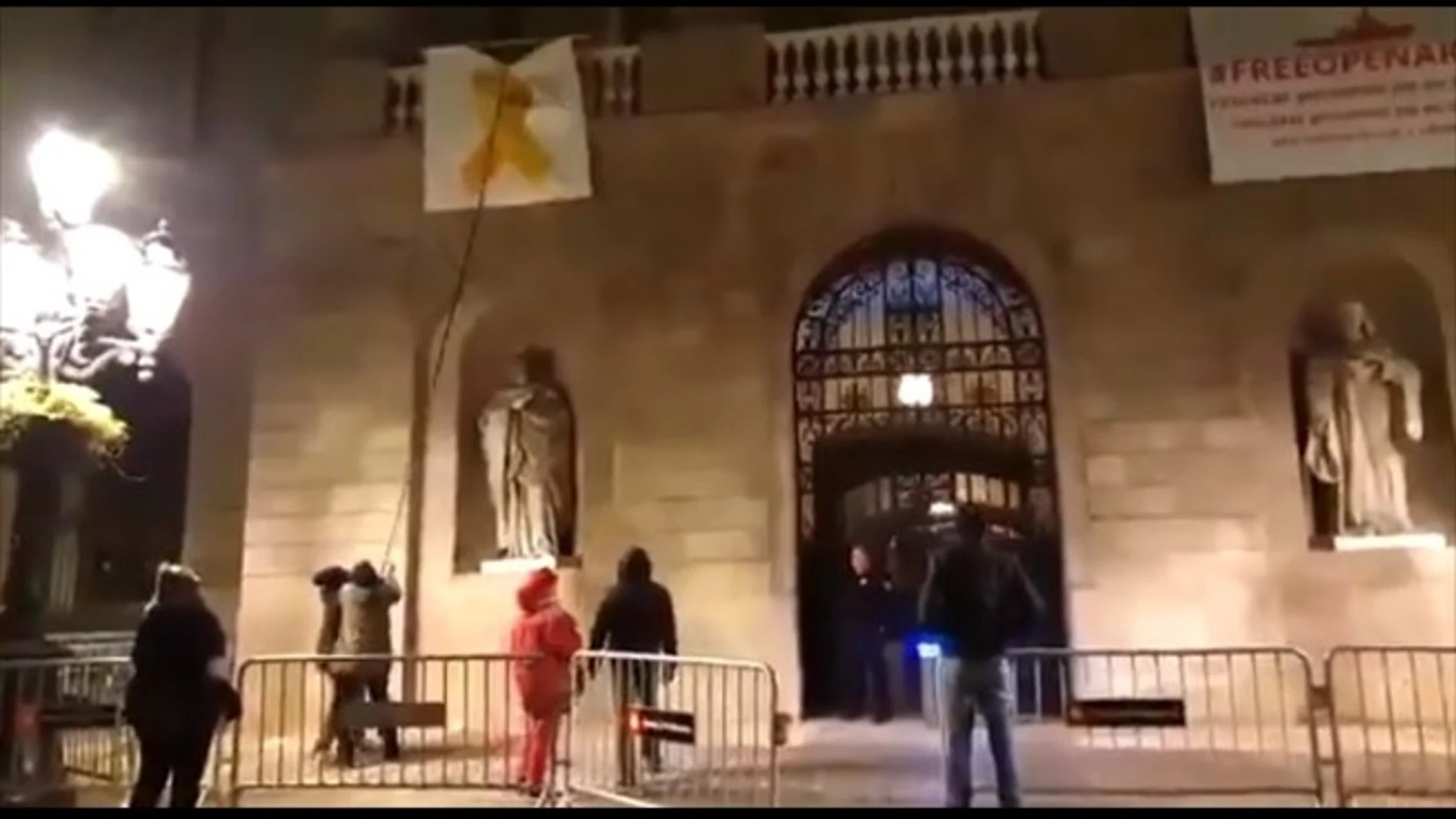 Un grupo de personas retiran el lazo amarillo del Ayuntamiento de Barcelona Un grupo de personas retiran el lazo amarillo del Ayuntamiento de Barcelona