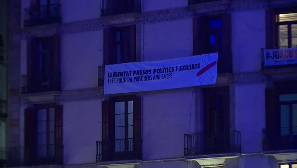 La pancarta retira de la Generalitat aparece colgada en un edificio particular en Sant Jaume