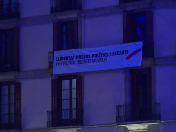 La pancarta retira de la Generalitat aparece colgada en un edificio particular en Sant Jaume