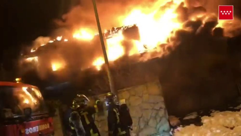 Un total de ocho dotaciones de bomberos trabajan para extinguir un incendio en un chalet de madera en Madrid