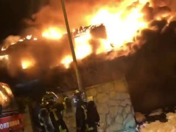 Un total de ocho dotaciones de bomberos trabajan para extinguir un incendio en un chalet de madera en Madrid