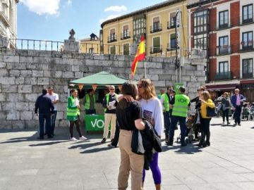 La pareja besándose frente al puesto de Vox