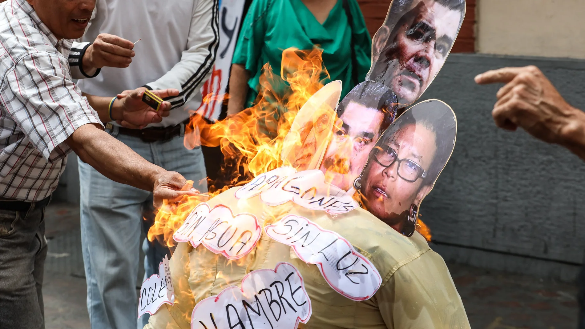 Un grupo de personas quema un muñeco con la foto de la cara de Nicolás Maduro Un grupo de personas quema un muñeco con la foto de la cara de Nicolás Maduro