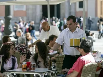 Un camarero atiende una mesa. Un camarero atiende una mesa.