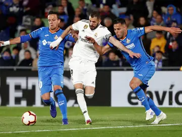 Benzema conduce el balón ante la defensa de los jugadores del Getafe Benzema conduce el balón ante la defensa de los jugadores del Getafe