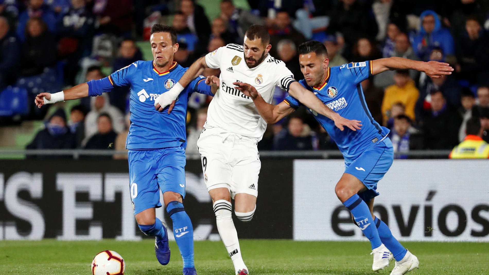 Benzema conduce el balón ante la defensa de los jugadores del Getafe Benzema conduce el balón ante la defensa de los jugadores del Getafe