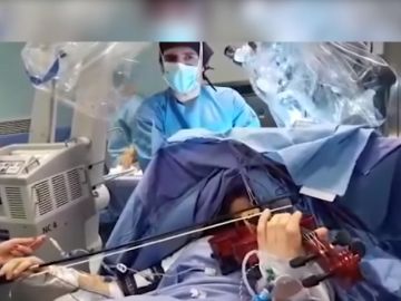 Imagen de la mujer tocando el violín mientras es operada